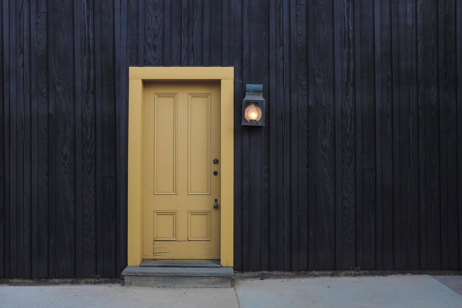 A closed yellow door set in a dark wooden wall
